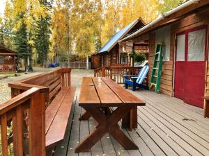 a wooden picnic table on the deck of a cabin at Sven's Basecamp Hostel in Fairbanks