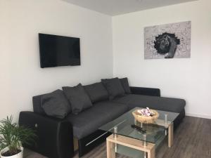 a living room with a black couch and a table at Ferienwohnung Schlossblick in Kippenheim