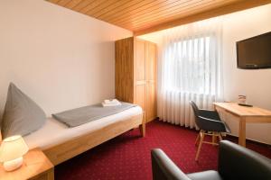a hotel room with a bed and a desk and a chair at Hotel Leitner in Kaufbeuren