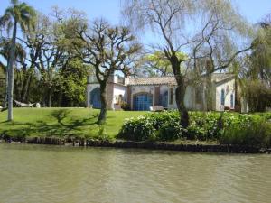 ein Haus neben einem Wasserkörper in der Unterkunft Charqueada Santa Rita Pousada de Charme in Pelotas