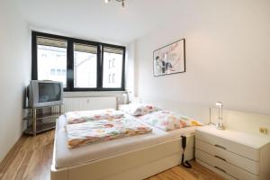 Un dormitorio con una cama y un televisor. en Altstadt Kunstmuseum, en Düsseldorf