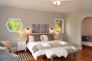 a bedroom with a bed and a chair and two windows at Sunshine Villa B&B in Madeira Park