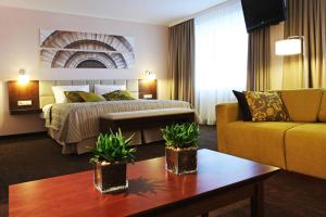 una habitación de hotel con una cama y un sofá en Mercure Marijampole, en Marijampolė 58 fotos más