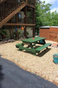 un tavolo da picnic verde di fronte a una casa di Shady Acre Inn and Suites a Branson West