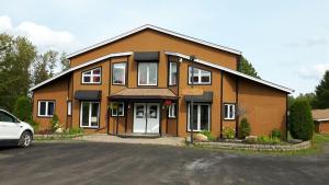 a house with a car parked in front of it at Chalets du Lac Matapédia in Val-Brillant