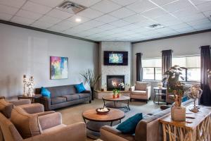 a living room with couches and chairs and a fireplace at Heartland Inn Coralville in Coralville