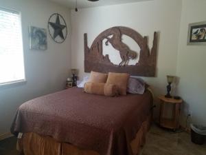 Un dormitorio con una cama con cabecero de madera. en Grizzly Roadhouse Bed and Breakfast, en Cortez