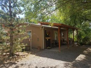 una pequeña casa en el bosque con porche en Grizzly Roadhouse Bed and Breakfast, en Cortez