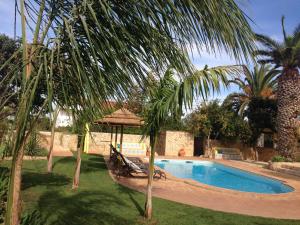 einen Pool mit einem Pavillon und einer Palme in der Unterkunft Casa Paula Villas - Private Heated Pool for Each House in Lagos