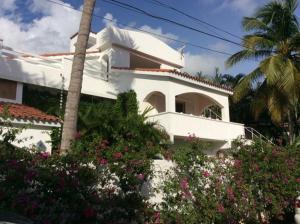 una casa blanca con flores delante en Caraibidamari en Bayahibe