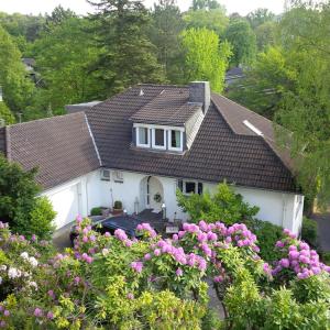 a white house with a brown roof and some flowers at Villa Hortensie in Aachen