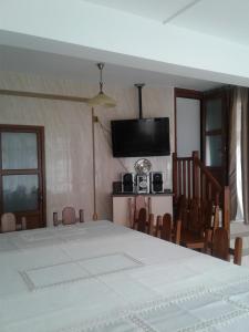 a dining room with a table and a television at Casa Teju in Slănic