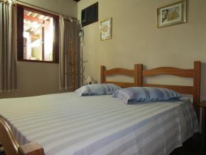 a bedroom with a bed with two pillows on it at Pousada Seachegue in Ubatuba +11 photos