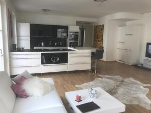 een woonkamer met een witte bank en een keuken bij Luxury 145 m2 Apartment with Terrace in Berlijn