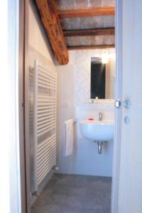 a white bathroom with a sink and a mirror at La Meridiana in Crocetta del Montello