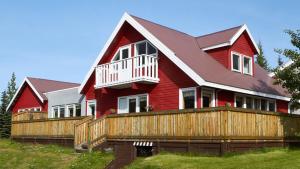 una gran casa roja con una valla de madera en Hótel Eyvindará en Egilsstadir
