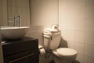 y baño con aseo y lavabo con toallas. en Amg Apartments San Sebastian, en Santiago