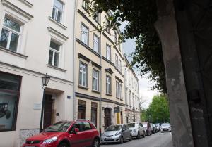 un'auto rossa parcheggiata in una strada accanto agli edifici di Leonardo 2 a Cracovia