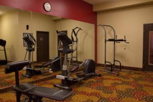 a gym with several tread machines in a room at Brentwood Suites in Brentwood