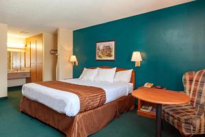 Habitación de hotel con cama, mesa y silla en America's Best Value Inn & Suites Bakersfield Central, en Bakersfield