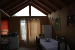 ein Esszimmer mit einem Tisch und einem Fenster in der Unterkunft Rosa Herminia in Limache