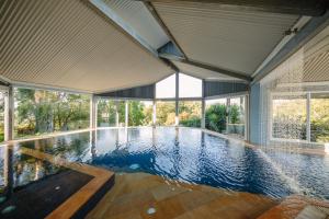 an empty swimming pool in a house with windows at Mt Hay Retreat in Berry