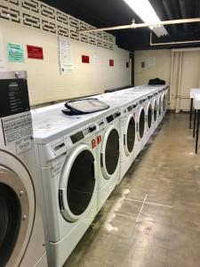 a row of washing machines in a laundry room at Downtown 1 Bedroom Apartment 18H in Atlanta