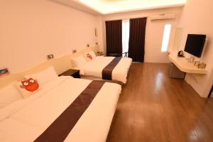 a hotel room with two beds and a flat screen tv at Red octopus in Magong