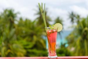 a drink sitting on a table with a lime in it at White Sand Dhigurah in Dhigurah