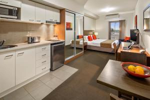 a kitchen and living room with a bed in a room at Quest Mildura in Mildura