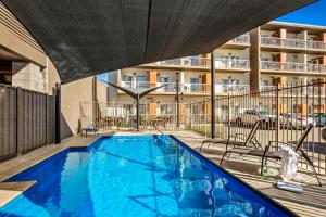 an indoor swimming pool with a building in the background at Quest Mildura in Mildura