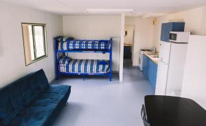 a small room with a couch and a refrigerator at Port Gregory Caravan Park in Gregory