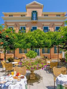 a patio with tables and chairs and a building at Bella Venezia in Corfu