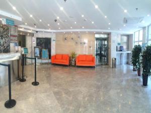 a lobby with two orange chairs in a building at Jinjiang Inn - Beijing Changchun Street in Beijing