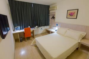 a hotel room with a bed and a desk and a window at Jinjiang Inn - Beijing Changchun Street in Beijing +23 photos