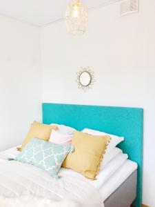uma cama com uma cabeceira azul com almofadas em Lahti Center Design Apartment Uno em Lahti
