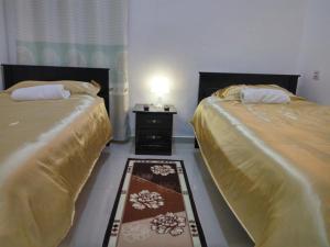 two beds sitting next to each other in a room at H2O Apartment in Cameron Highlands