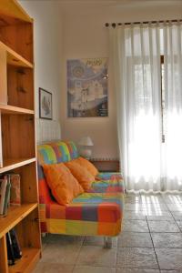 een slaapkamer met een bed, een raam en een boekenplank bij La Casa Di Famiglia in Assisi