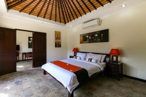 a bedroom with a large bed in a room at Aleesha Villas and Suites in Sanur +81 photos