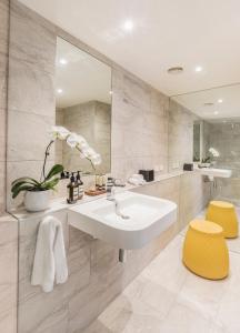 a bathroom with a sink and a mirror at Quay West Suites Melbourne in Melbourne