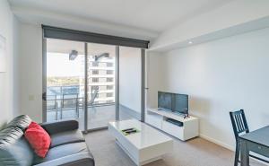 a living room filled with furniture and a tv at Eastwood Apartments in Brisbane