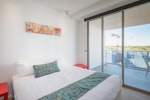 um quarto com uma cama e uma porta de vidro deslizante em Eastwood Apartments em Brisbane