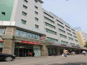 un grande edificio con persone che camminano davanti di Jinjiang Inn Beijing Wangfujing a Pechino