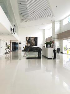 a man standing in the middle of a white lobby at SMDC Light Residences Condominium in Manila