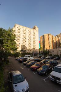 un parking avec des voitures garées devant un bâtiment dans l'établissement Jingjiang Inn Beijing Guang'anmen, à Pékin