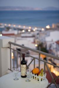 Una botella de vino y dos copas en una mesa. en Athena Apartments, en Agia Galini