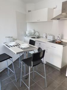 a white kitchen with a table and chairs in it at Casas Blancas Las Tortugas in Playa de las Americas