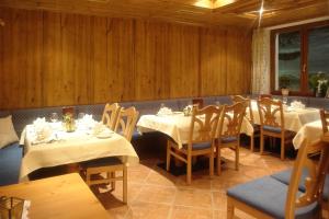 イシュグルにあるHotel Fatlarの白いテーブルと木製の壁が備わるダイニングルーム