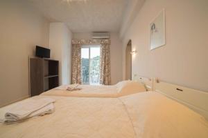 Un dormitorio con una cama grande y una ventana en Athena Apartments, en Agia Galini