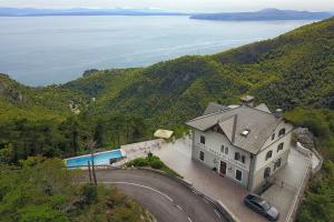
a house with a view of the ocean and mountains at Hotel Draga di Lovrana in Lovran
